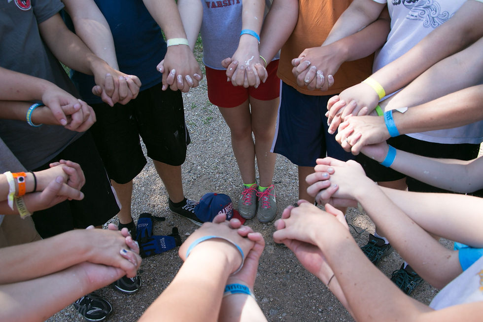 A group of teens holding hands in prayer