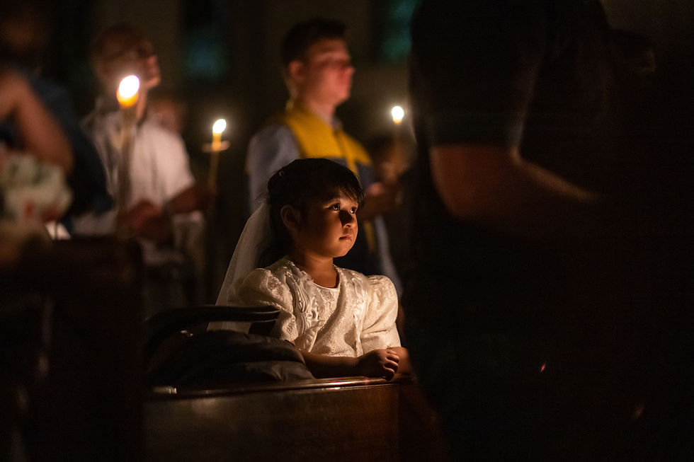 A girl in her first communion dress kneeling in church
