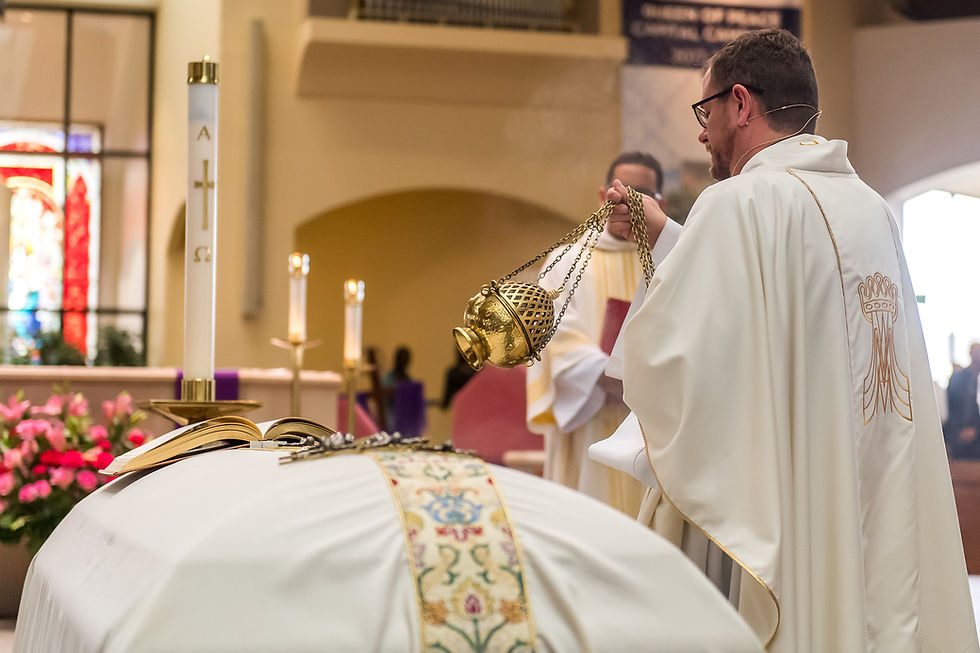 A priest in white blessing an altar with a gold thurible