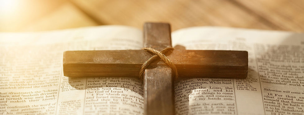 A wooden cross laying on an open bible