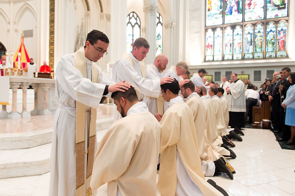 Priests kneeling and being ordained in a cathedral